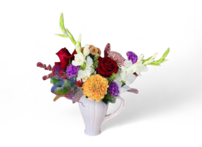 Nanna's Garden - Nanna’s Garden is a heartwarming arrangement inspired by the nostalgic beauty of a grandmother’s lovingly tended blooms. Featuring a medley of seasonal flowers in a classic ceramic pitcher, this piece brings a personal, storybook charm to any room. A sweet tribute to love, memory, and tradition—perfect for gifting or cherishing at home.
