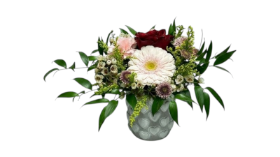 Blushing Hearts - Blushing Hearts is a delicate and romantic floral arrangement featuring soft blush tones paired with rich deep red blooms and fresh seasonal greenery. Beautifully designed in a charming heart-patterned pot (10x11cm), this arrangement symbolises love, tenderness and timeless elegance. Perfect for anniversaries, Valentine’s Day, birthdays or simply to show someone how much they mean to you.