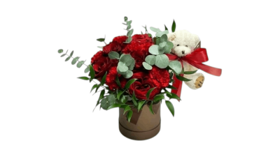 Crimson Cuddles - Crimson Cuddles is a stunning floral arrangement of rich red roses and textured carnations beautifully accented with fresh eucalyptus and lush greenery. Presented in a stylish brown hat box  (Size: 13 X 17 cm) and finished with a small sweet teddy bear, this arrangement is the perfect expression of love, affection and warmth — ideal for Valentine’s Day, anniversaries, or to surprise someone special.